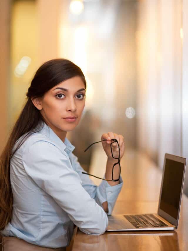 Serious Attractive Woman Working on Laptop in Cafe