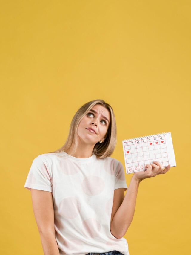 woman-looking-up-holding-menstruation-calendar